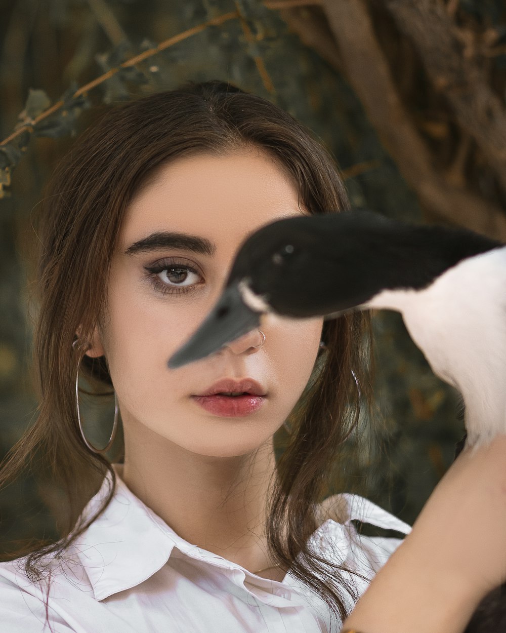 woman in white shirt holding black and white bird