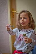 A cheerful child exploring a colorful science experiment with Abby the figure.
