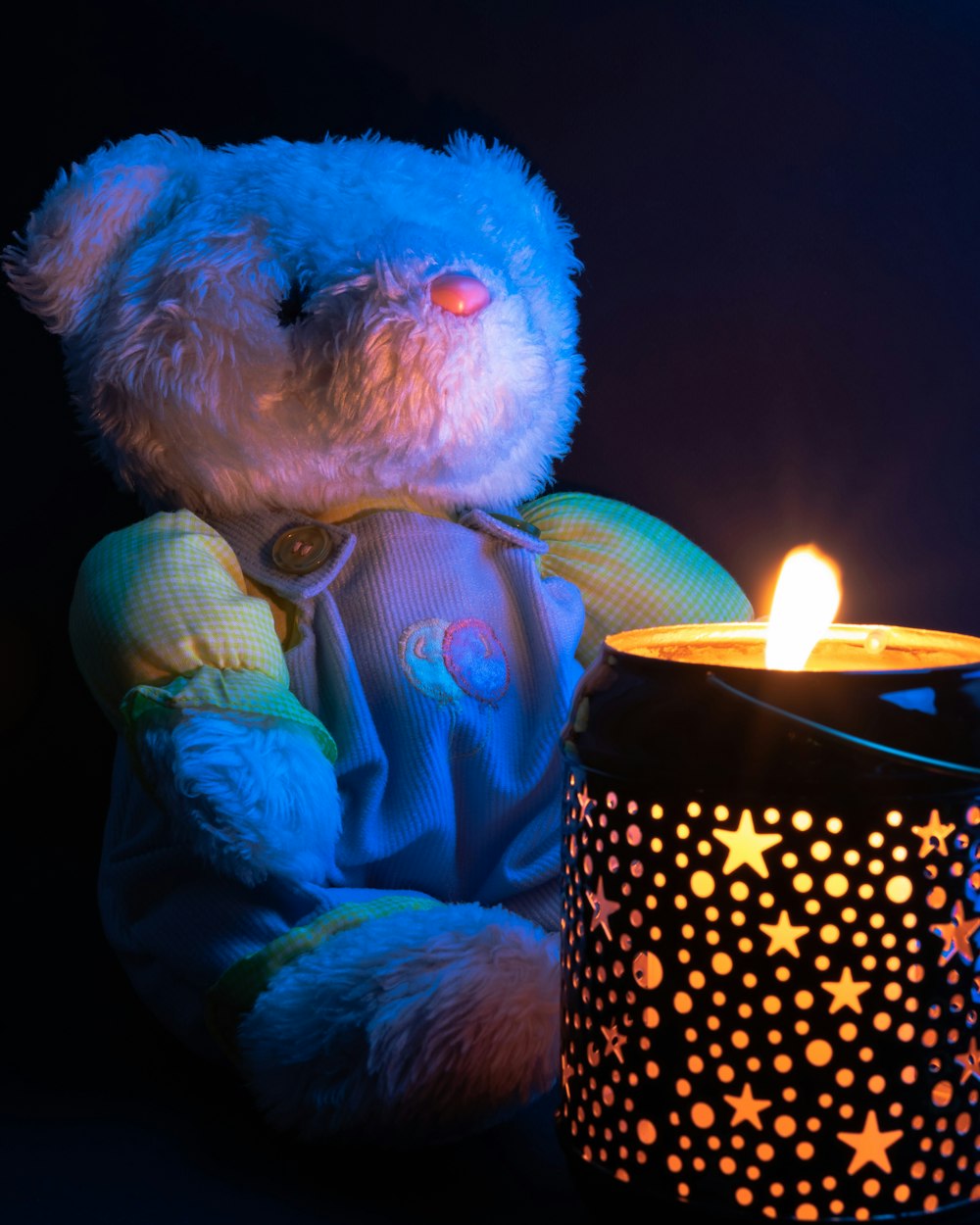 juguete de peluche de oso blanco sosteniendo vela encendida
