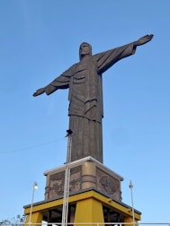 man in robe statue under blue sky during daytime