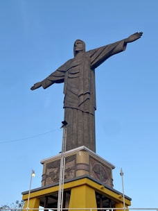 man in robe statue under blue sky during daytime