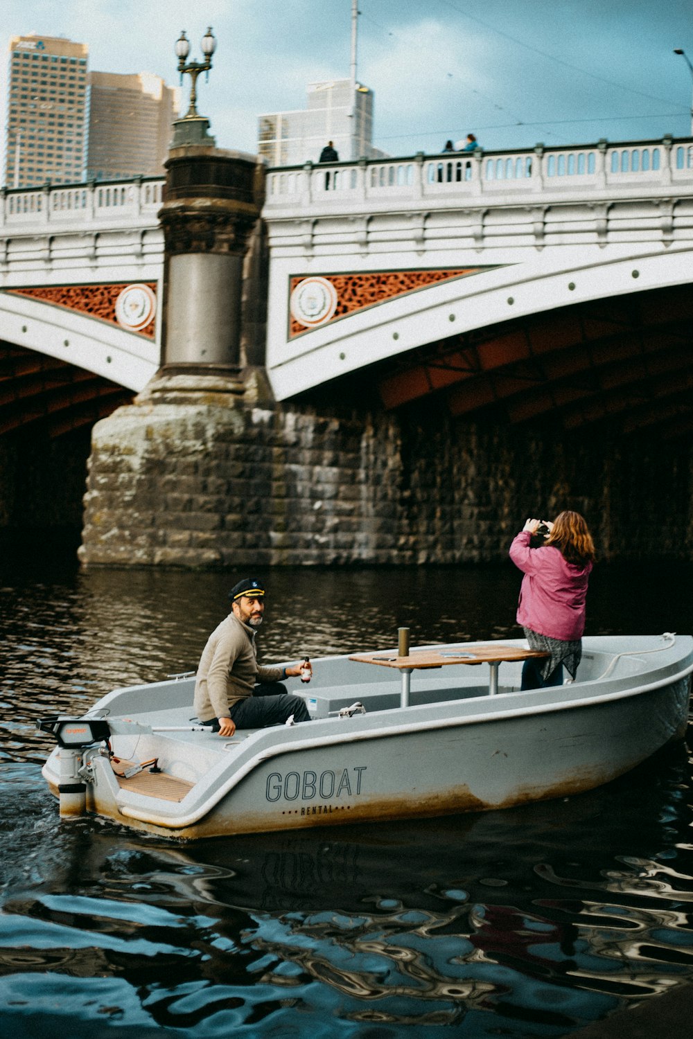 homme et femme sur un bateau blanc et bleu sur la rivière pendant la journée