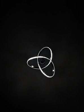 A minimalist black and gold linear chandelier illuminating a sleek living room.