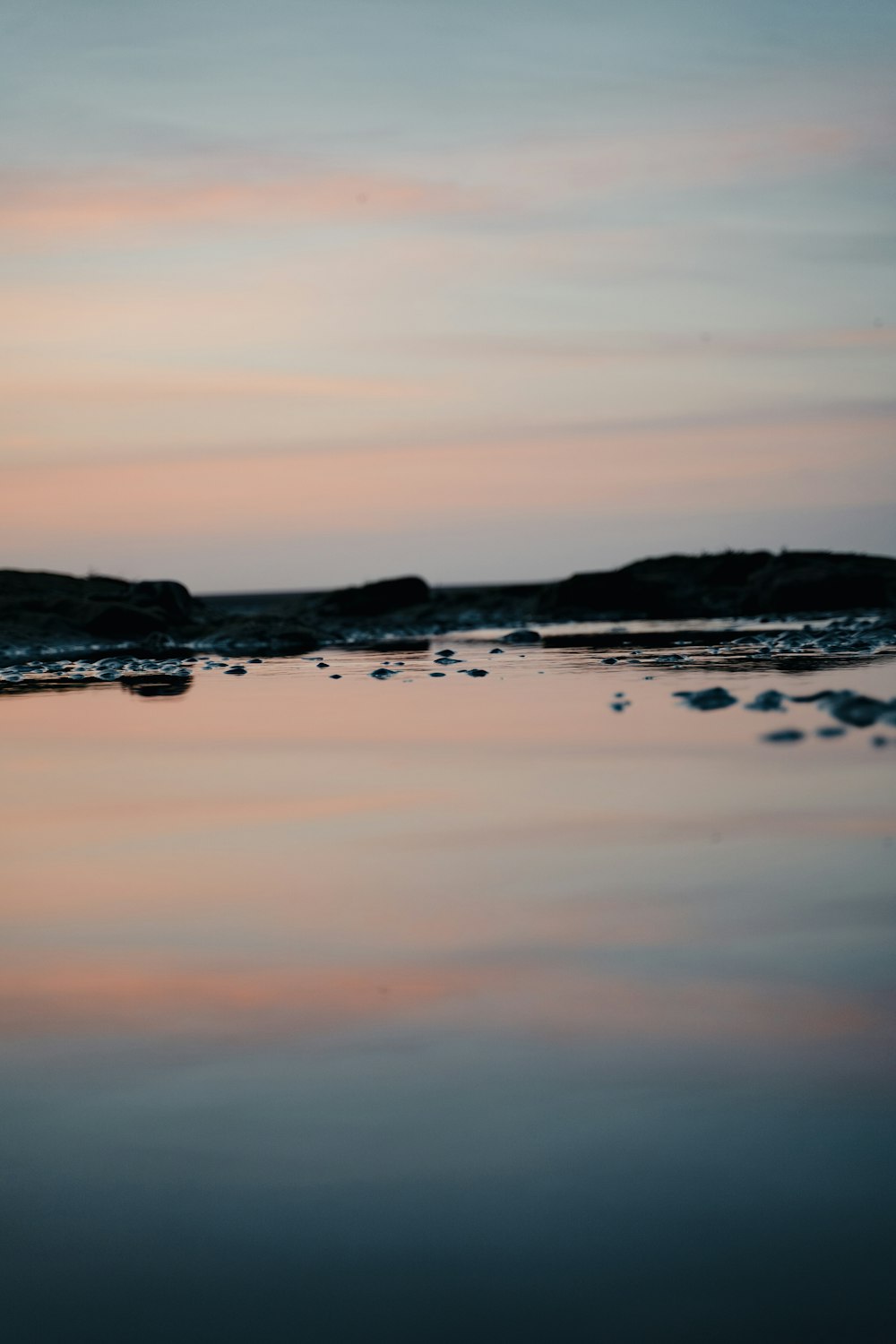 black rock formation on body of water during daytime