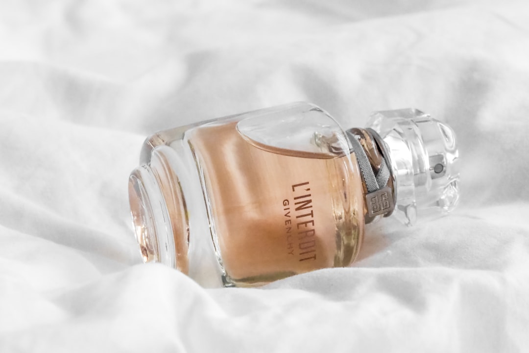 clear glass bottle on white textile