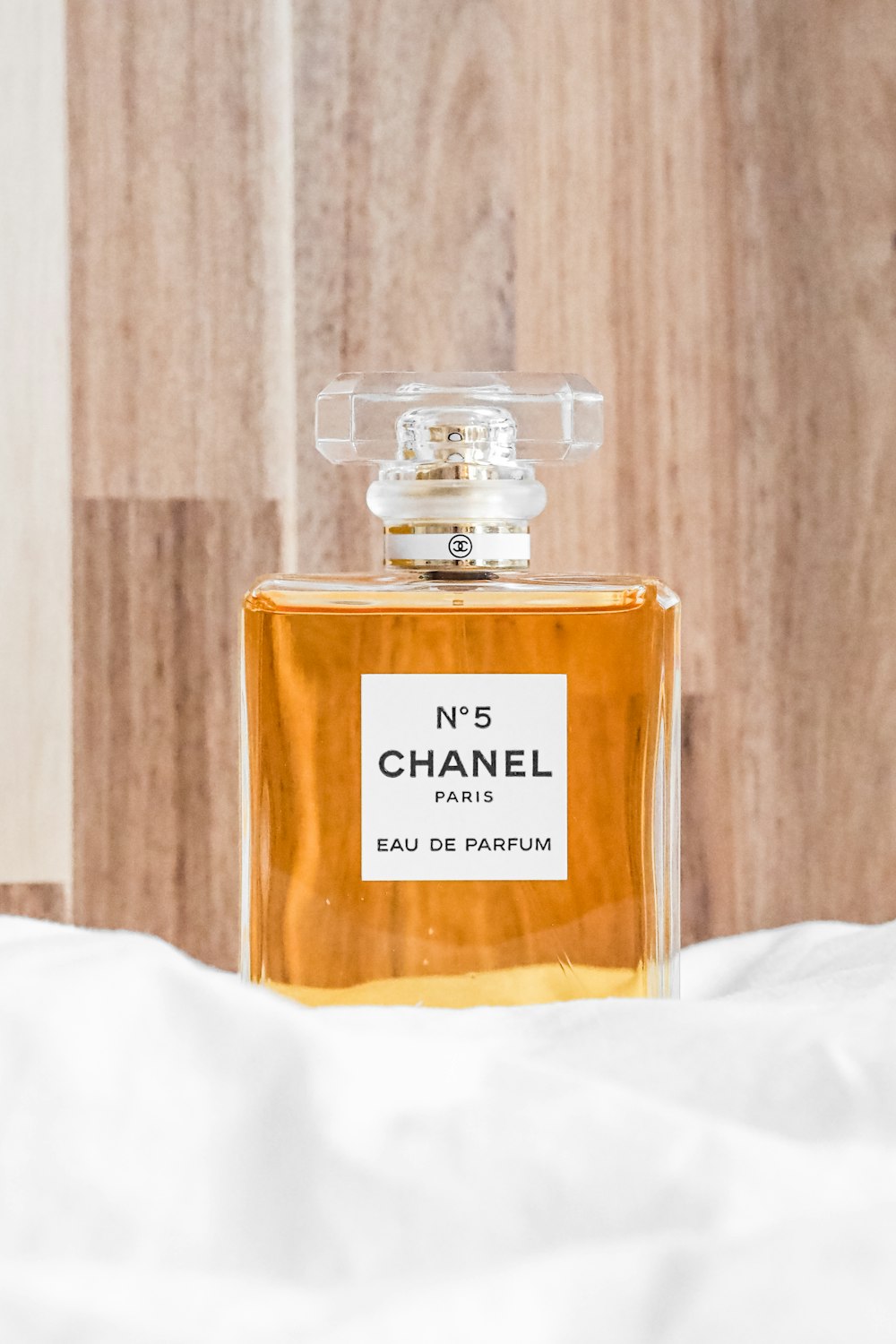 a bottle of chanel no 5 eau de parfum on a bed