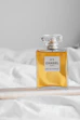 a bottle of perfume sitting on top of a bed