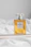 a bottle of perfume sitting on top of a bed