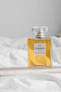 a bottle of perfume sitting on top of a bed