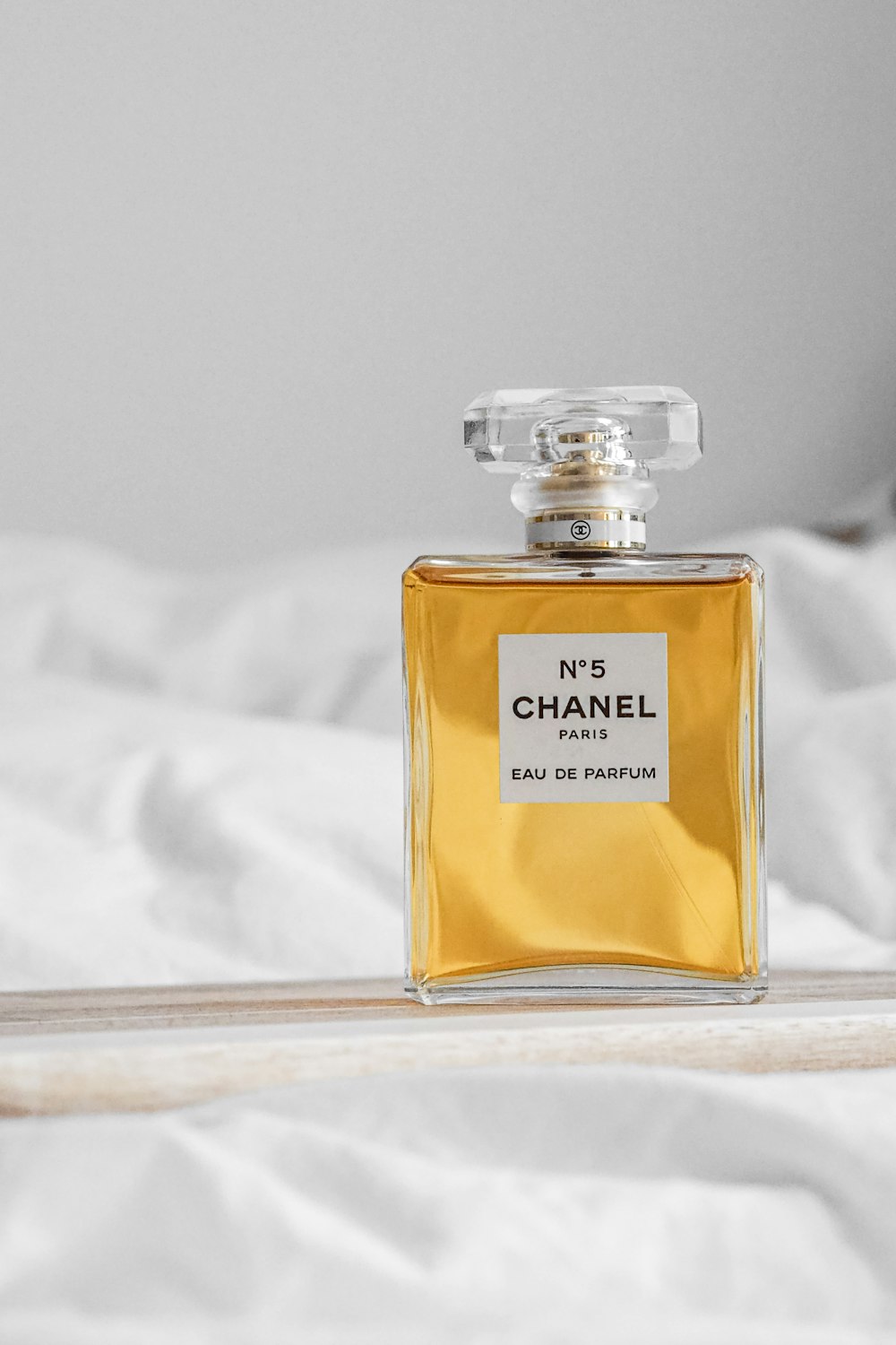 a bottle of perfume sitting on top of a bed