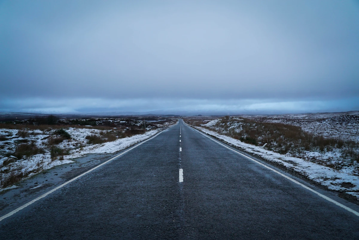 Straight highway across snowy tundra at dusk