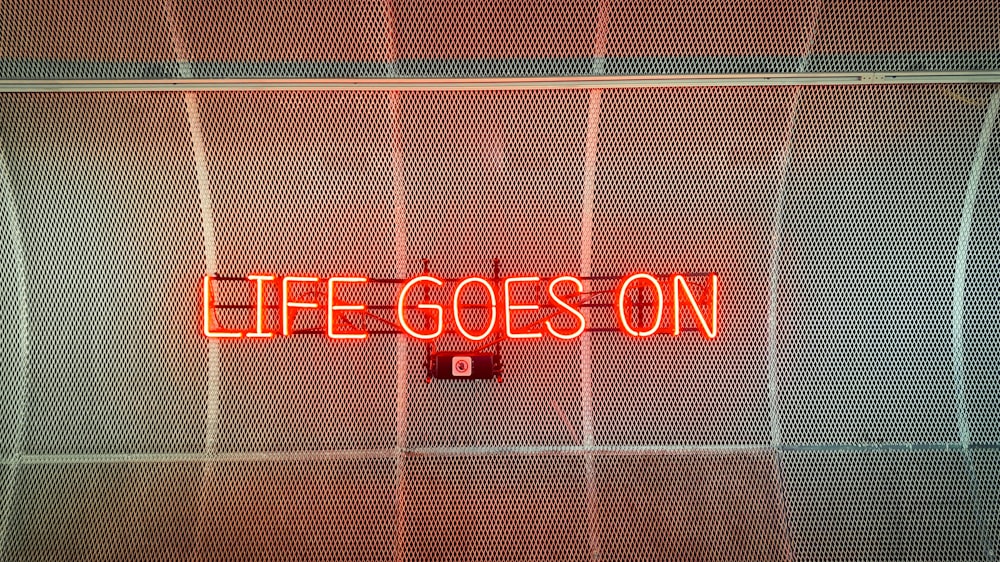 a neon sign that reads life goes on