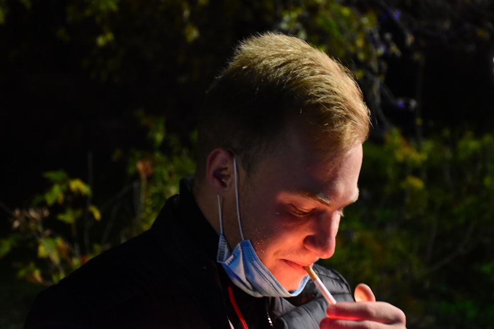 a man with ear buds on his ears is looking at his cell phone