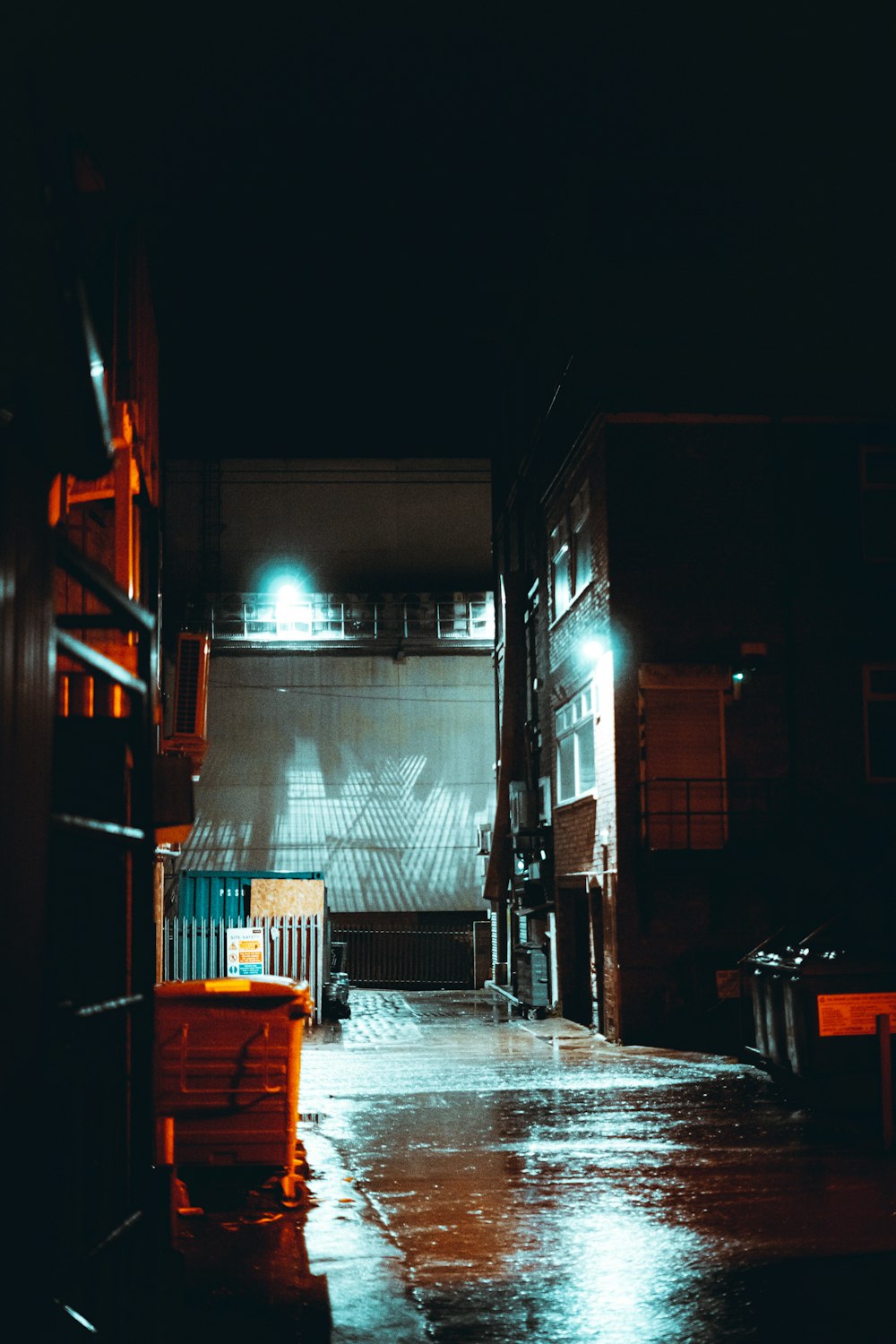 a dark alley with a bench in the middle of it