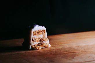 Close-up of a rich, purple velvet cake with creamy frosting glowing under soft light