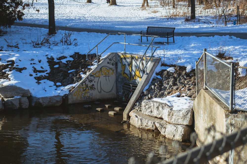 black metal bench near body of water during daytime