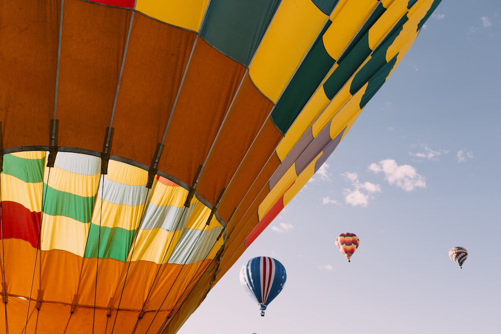 yellow green and red hot air balloon in mid air during daytime
