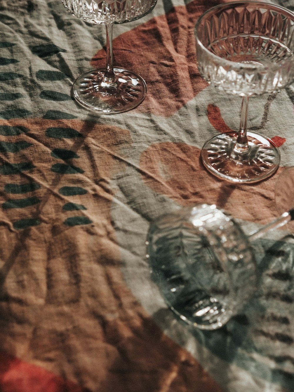 Copa de vino transparente sobre textil marrón y blanco