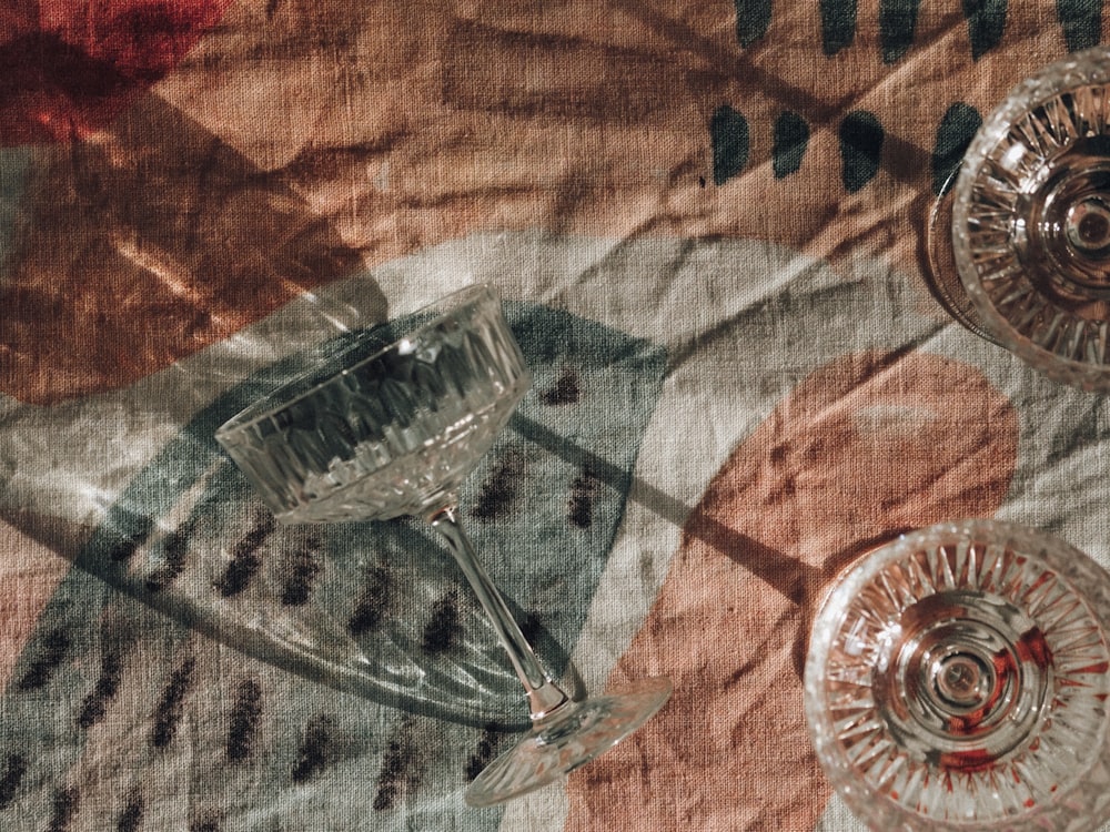 clear glass bowl on brown and white textile