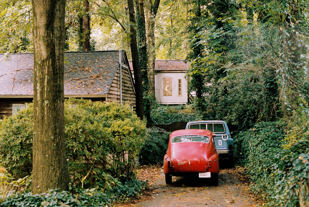 red volkswagen beetle parked beside brown wooden house