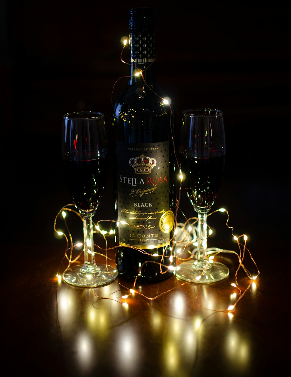 wine bottle with wine glass and wine glass on table