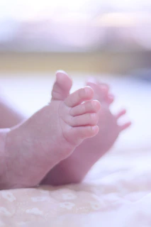 Close-up of tiny baby feet resting on a soft hospital blanket, symbolizing new life and care.