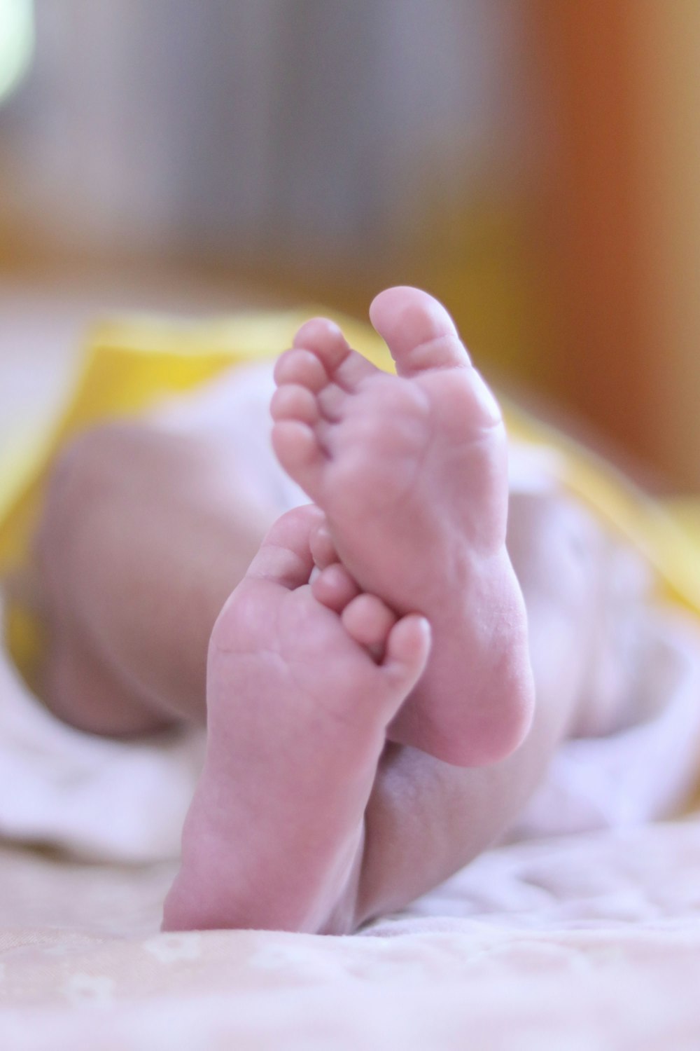 babys feet on white textile