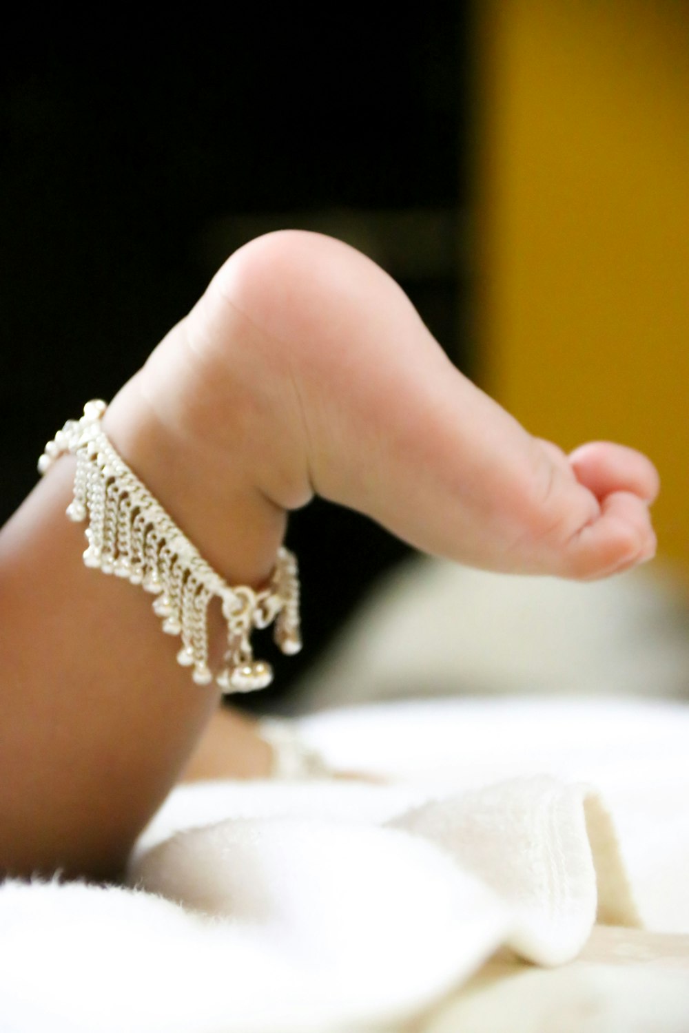 babys feet on white textile