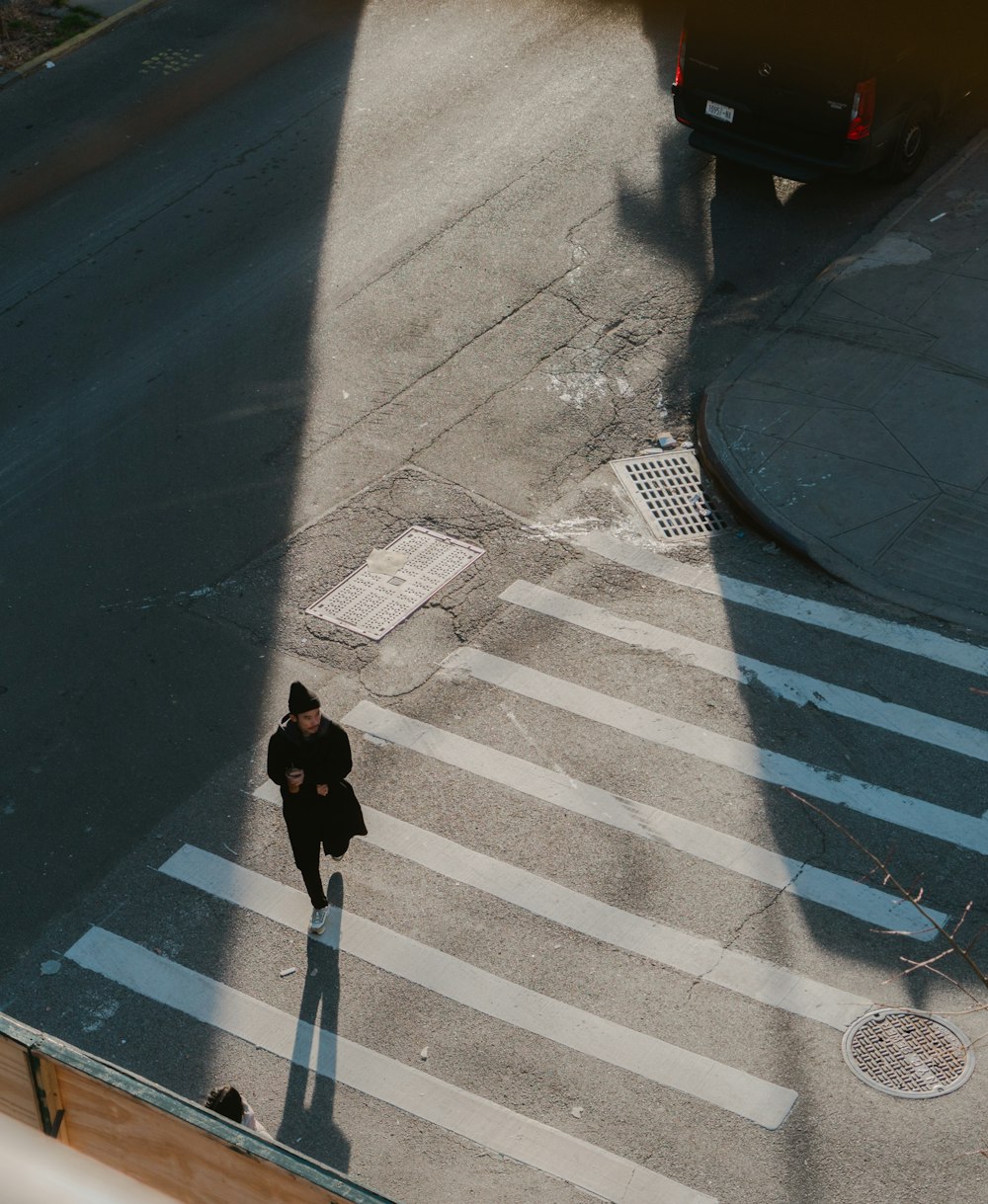 black short coated medium sized dog on pedestrian lane