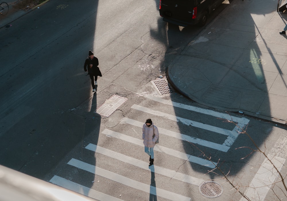 man in black jacket walking on pedestrian lane during daytime