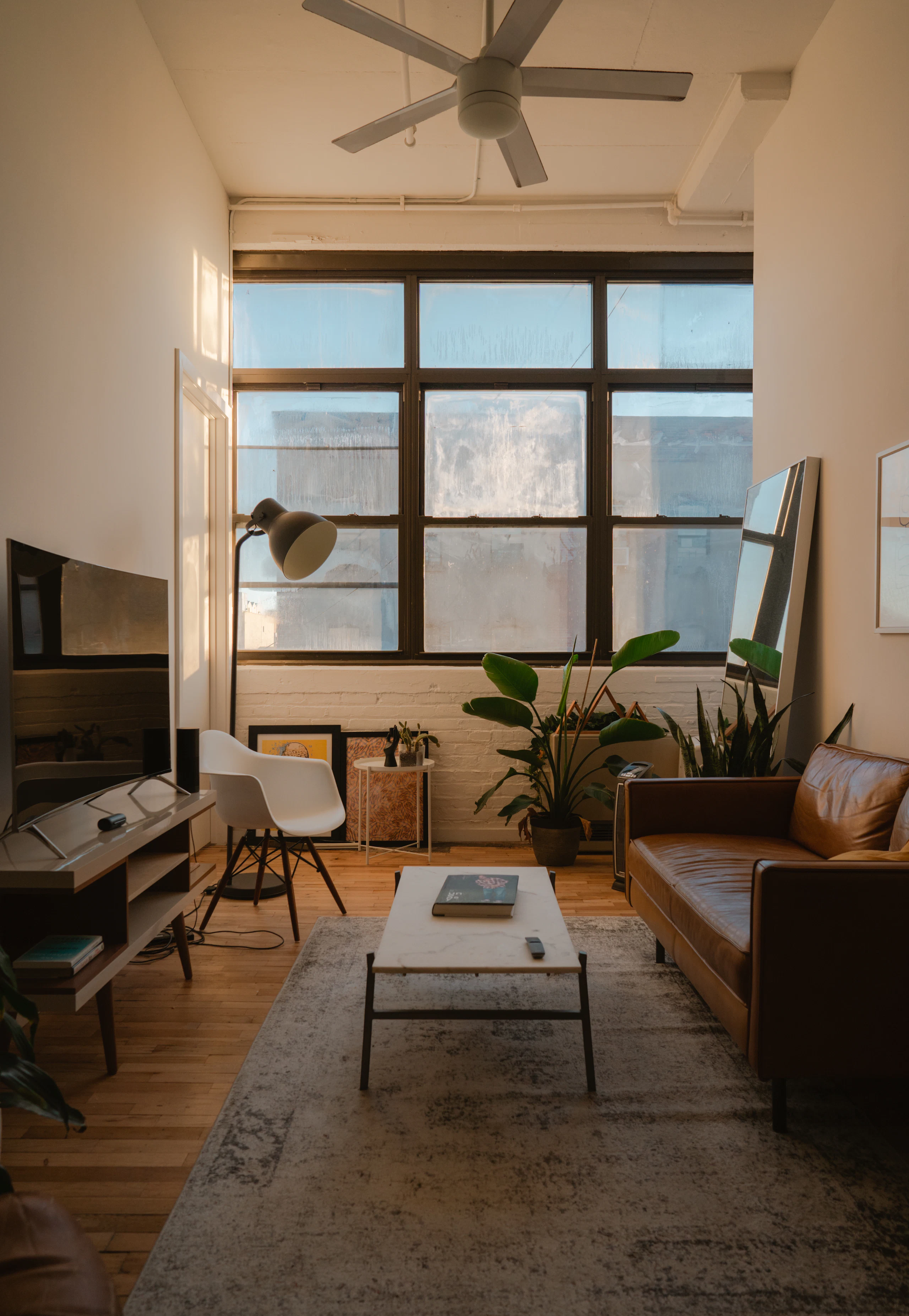 A living space with a large window and low warm furniture