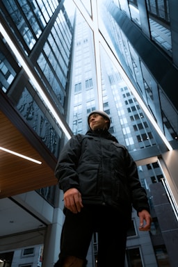 perspective and angle for photo composition,how to photograph low angle portraits ; woman in black leather jacket standing near glass window