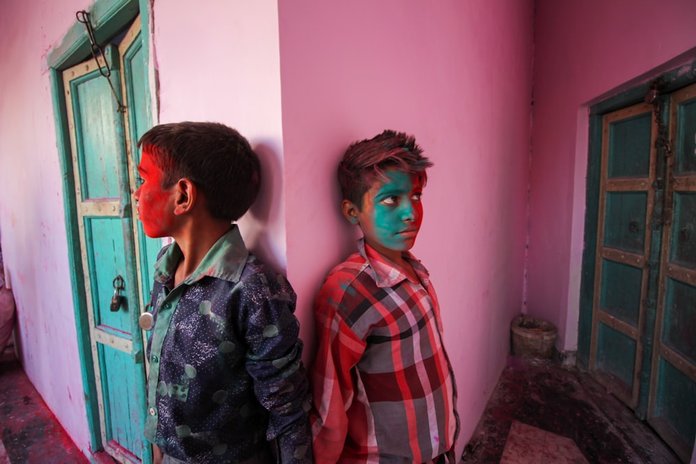 2 women standing near pink wall