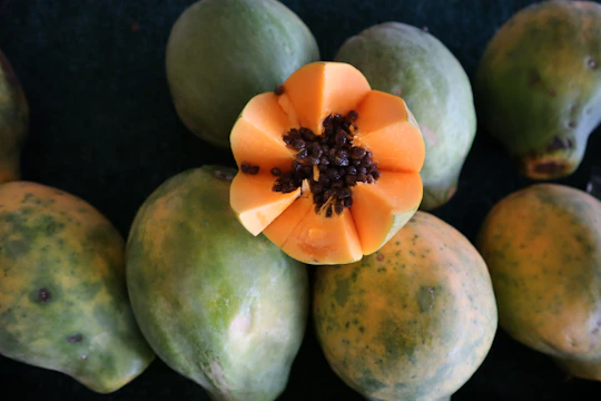 Close-up of vibrant papaya seeds arranged neatly on a rustic wooden table.