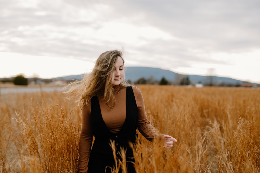 woman in black long sleeve shirt standing on brown grass field during daytime