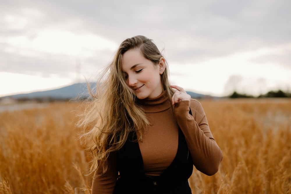 woman in black tank top standing on brown grass field during daytime