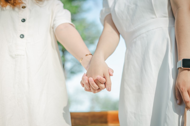 woman in white dress holding hands with girl in white dress
