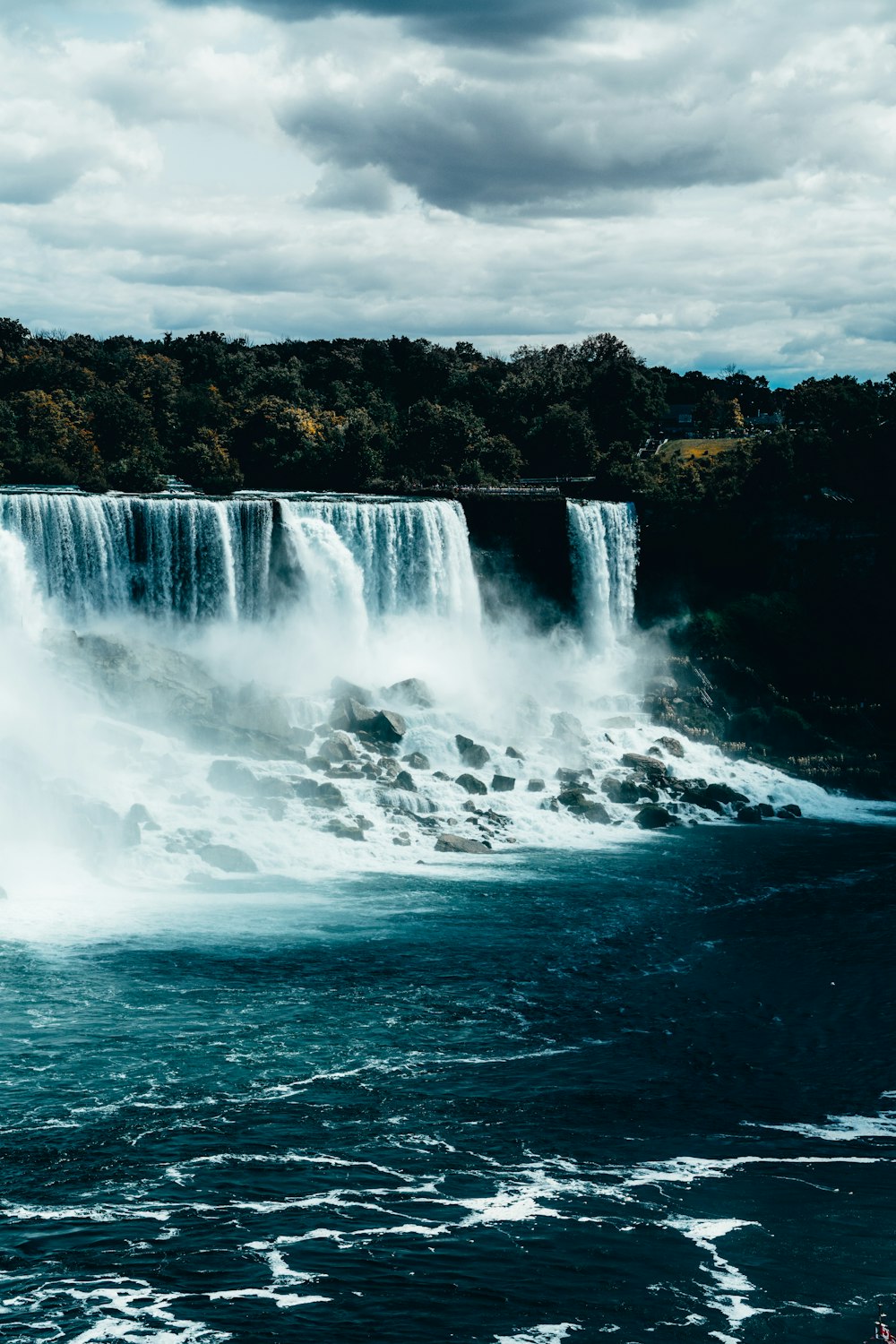 water falls on rocky shore during daytime