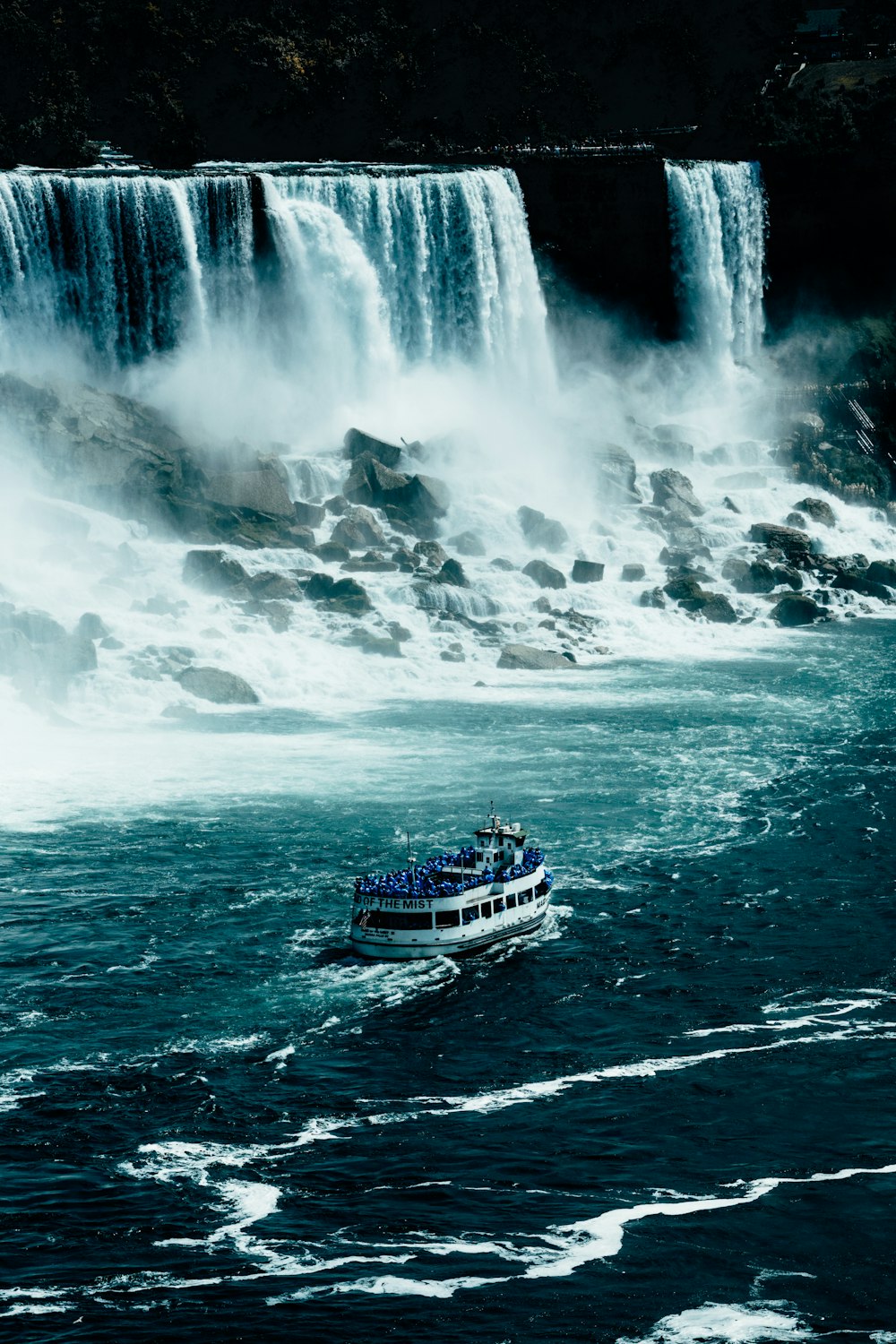white and blue ship on water falls