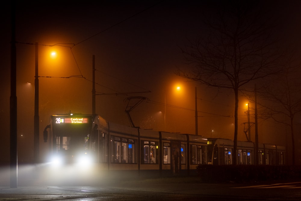treno marrone e bianco sulla strada durante la notte