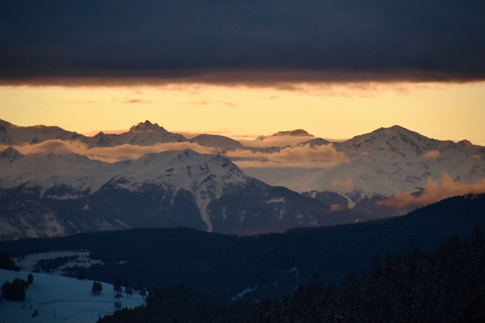 snow covered mountains during sunset