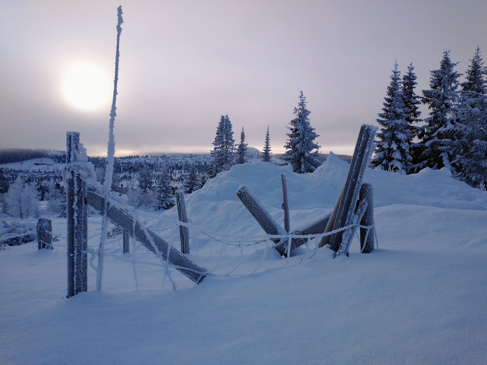 brauner Holzzaun tagsüber auf schneebedecktem Boden