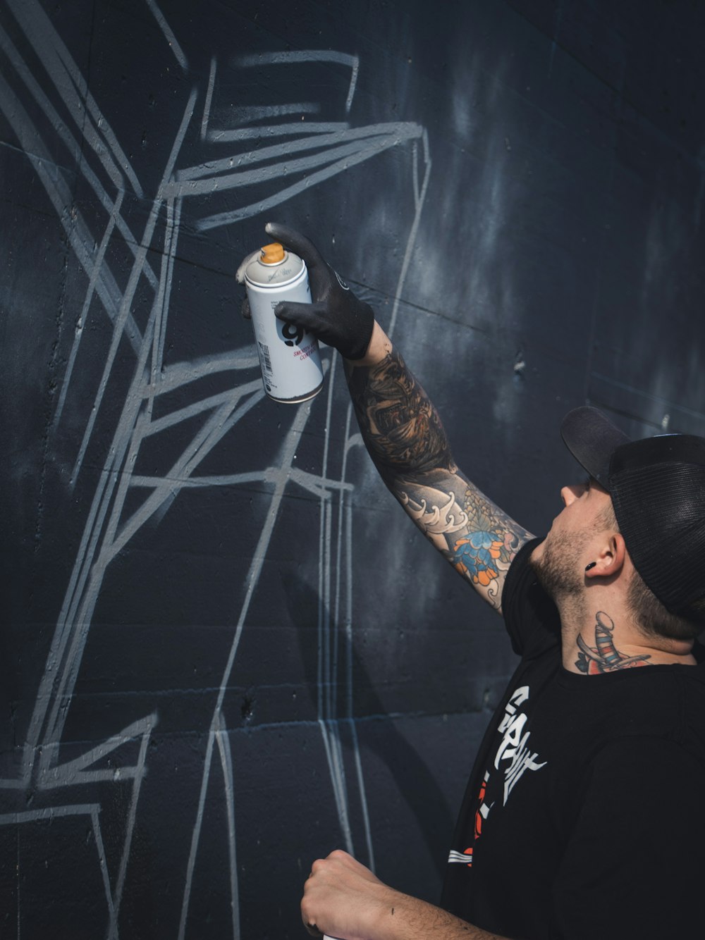 man in black crew neck t-shirt holding white and blue plastic bottle