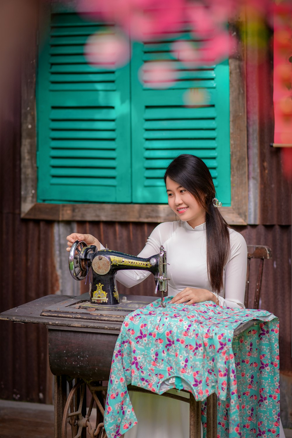 woman in white tank top and pink floral skirt sitting on chair