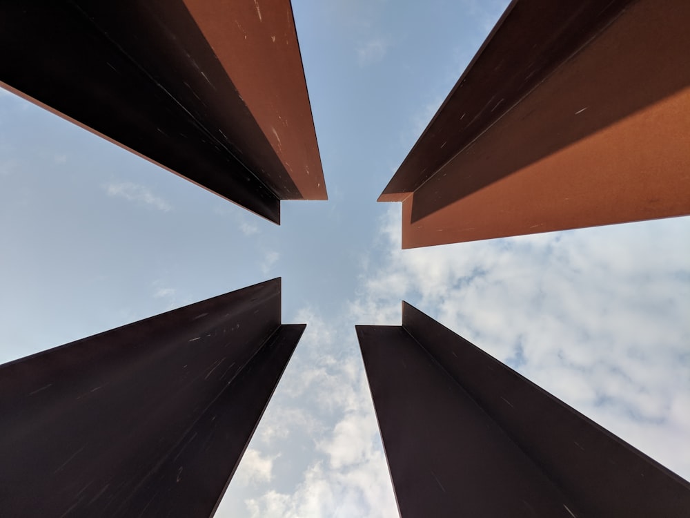 brown and black metal frame under white clouds and blue sky during daytime