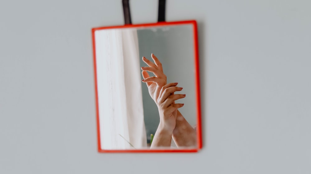 person holding red and white frame
