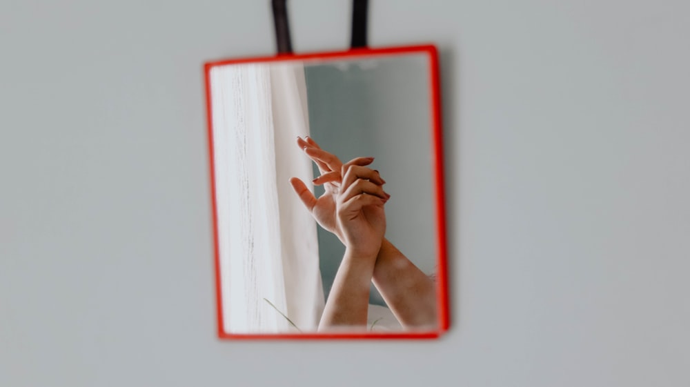 woman covering her face with red frame