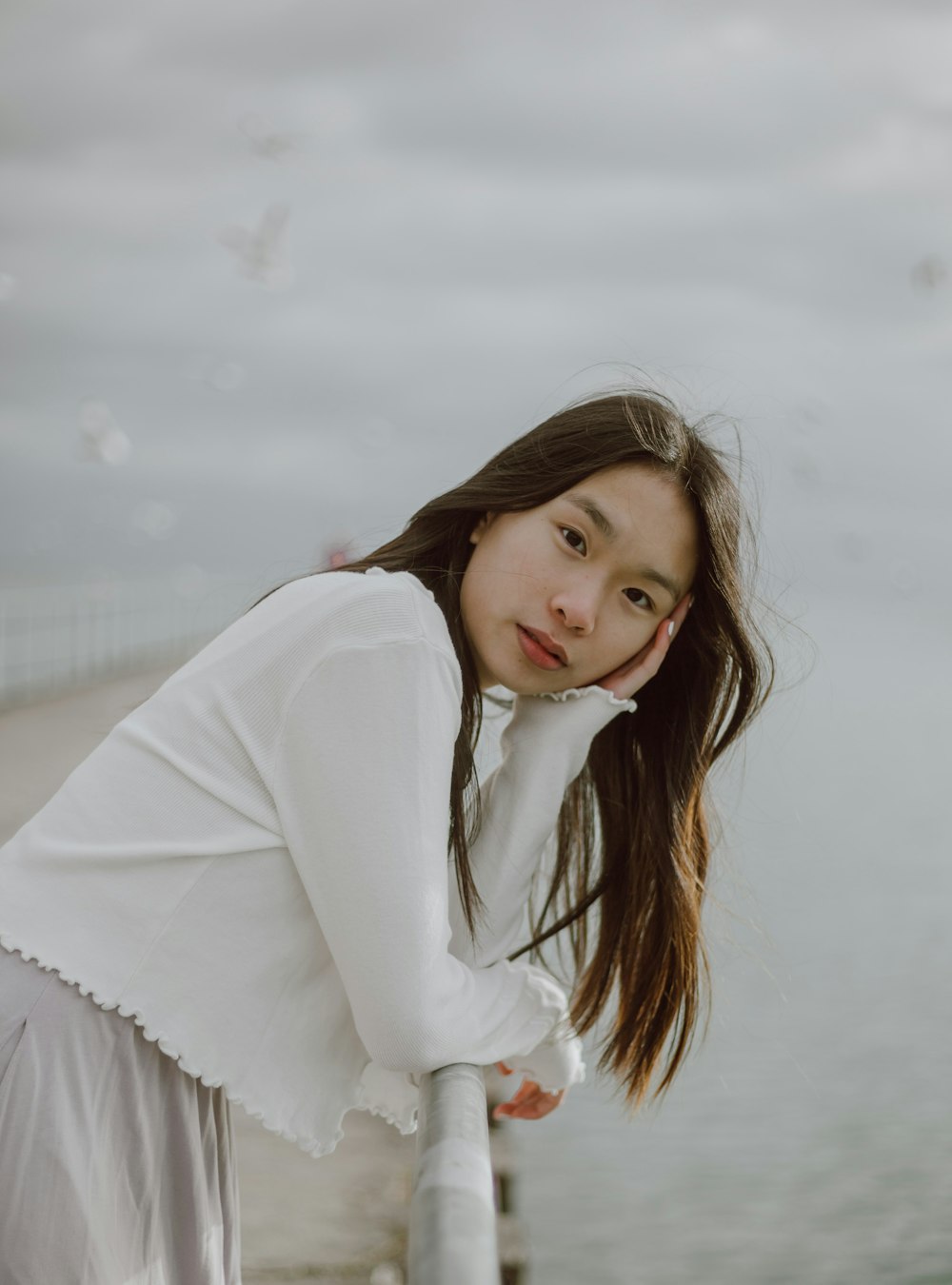 woman in white long sleeve shirt standing on snow covered ground during daytime