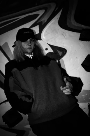 A model wearing a black cap with the 'No Filter, No Apologies' slogan, standing against a graffiti wall.