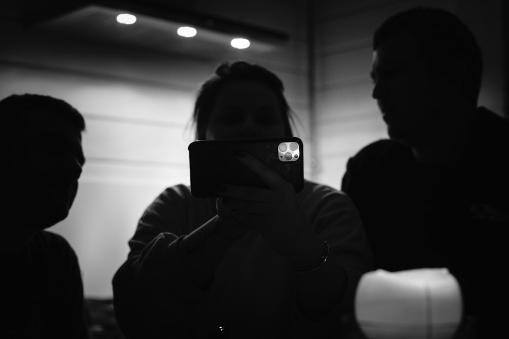 man in black hoodie holding smartphone